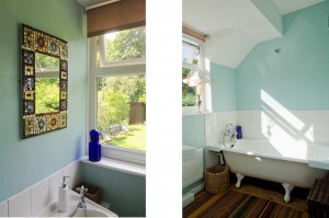 sunny bathroom with garden views and vintage Victorian bath at The Pink House Lulworth Dorset